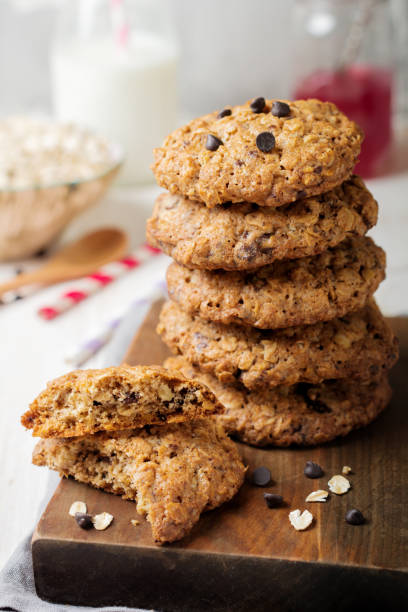 istock Stack of oatmeal cookies with chocolate on a light background with flakes and a bottle of milk. Selective focus. 1255018403