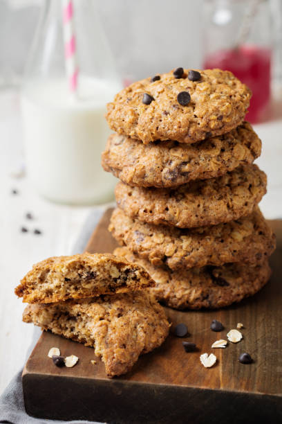 istock Stack of oatmeal cookies with chocolate on a light background with flakes and a bottle of milk. Selective focus. 1255018504