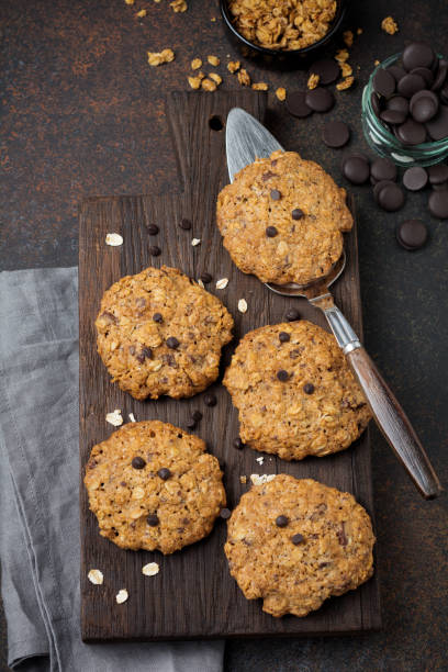 istock Stack of oatmeal cookies with chocolate and flakes on dark rusty concrete or stone background. Selective focus. Top view. Copy space. 1255018570
