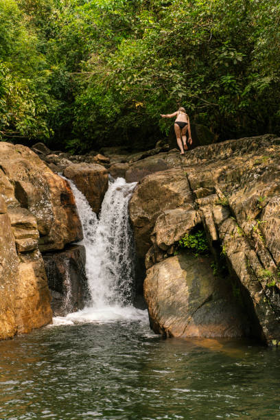 vacances tropicales. femme blanche caucasienne active mature, une touriste, marchant autour de la cascade de polgampola (thambadola ella) au sri lanka. - ella sri lanka photos et images de collection