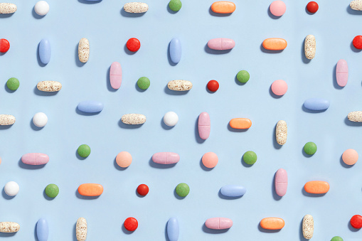 Colorful pills on soft blue background