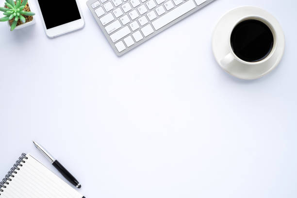 istock White office desk table with keyboard, notebook and coffee cup with equipment other office supplies. Business and finance concept. Workplace, Flat lay with blank copy space, top view. 1255022182