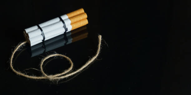istock Cigarettes are twisted into a dynamite checker with a filament on a black reflective surface. 1255022887