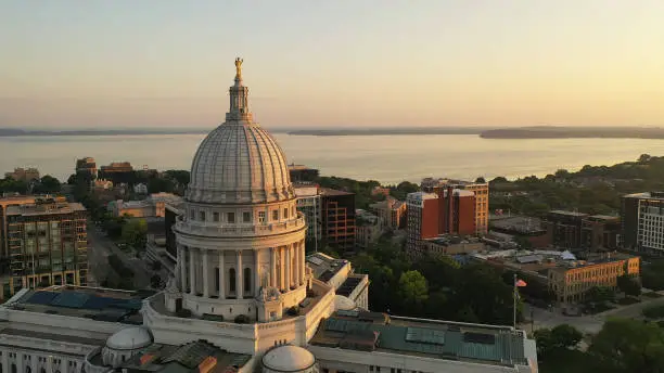 Photo of Aerial view of City of Madison. The capital city of Wisconsin from above. Drone flying over Wisconsin State Capitol in downtown. Sunny morning, sunrise (sunset), sunlight, summertime