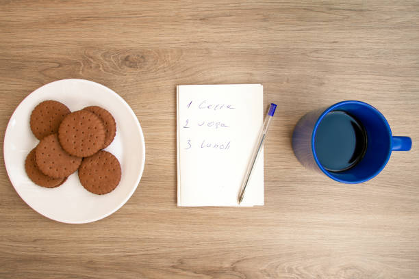 istock Good morning with coffee. A cup of coffee in blue. Biscuits.  Notepad with daily routine. 1255029446