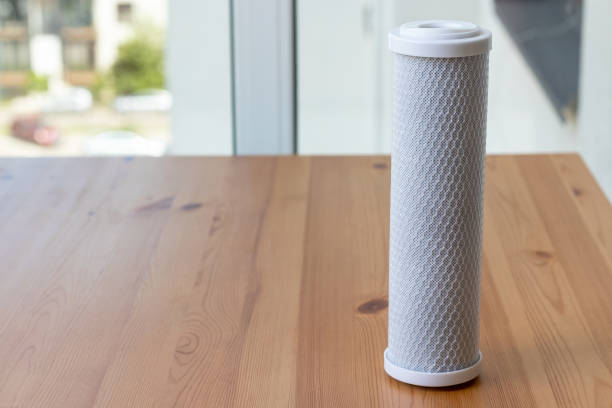 istock Filter cartridge for drinking water purification for on a wooden table against a blurred background. Water filtration RO (reverse osmosis) system 1255030920