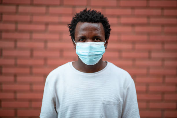 istock African-American young man with protective face mask staring at camera 1255032759