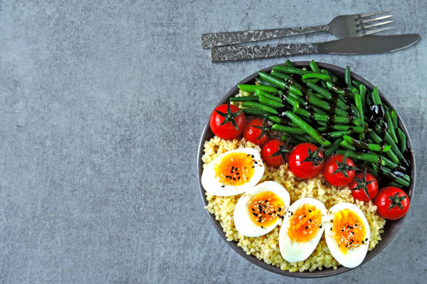 istock Buddha bowl with bulgur, green beans, cherry tomatoes and boiled egg halves. 1255032876