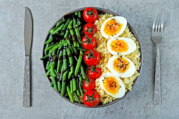 istock Buddha bowl with bulgur, green beans, cherry tomatoes and boiled egg halves. 1255032877