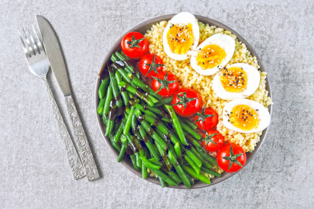 istock Buddha bowl with bulgur, green beans, cherry tomatoes and boiled egg halves. 1255032880