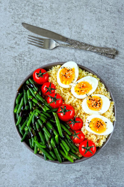 istock Buddha bowl with bulgur, green beans, cherry tomatoes and boiled egg halves. 1255032881