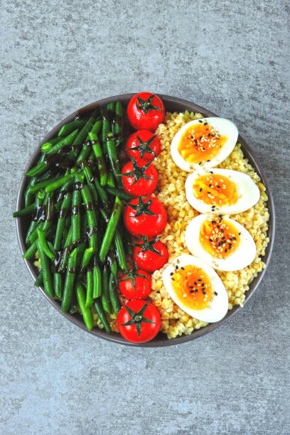 istock Buddha bowl with bulgur, green beans, cherry tomatoes and boiled egg halves. 1255032896