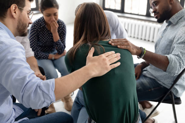 durante la sessione di terapia di gruppo i membri sostengono il pianto ragazza disperata - alcoholism assistance photography people foto e immagini stock