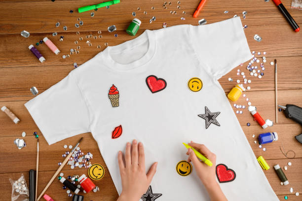 istock Woman drawing on a t-shirt using a fabric marker 1255034277