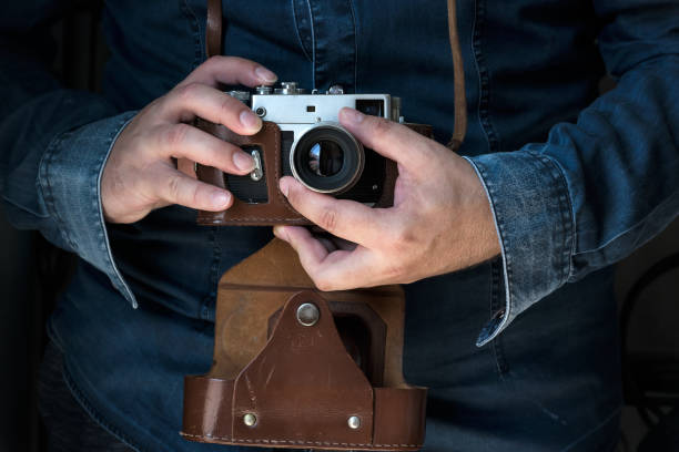 istock Men holding an old film camera camera 1255035887