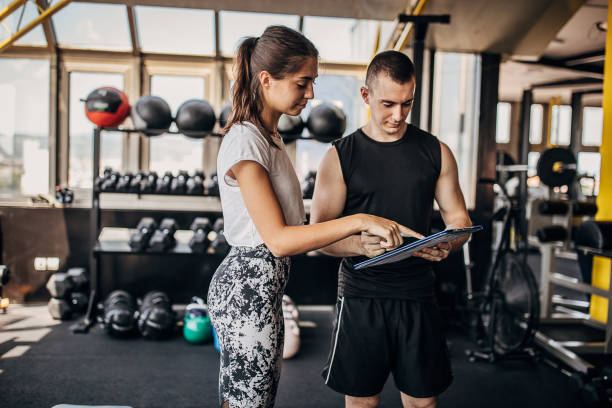 istock Fit woman and her personal trainer making exercise plan 1255035895