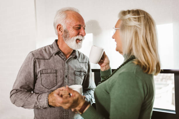 istock Senior couple holding white mugs at home 1255036002