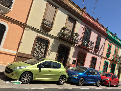 Valencia, Spain - June 26, 2020: Three colorful cars parked in the street. A lot of compact cars are moving around the city to avoid traffic issues