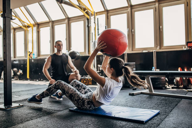 istock Young fit woman having personal training in the gym 1255036729