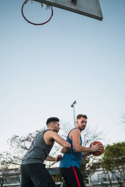 istock Two young friends playing basketball. 1255036892