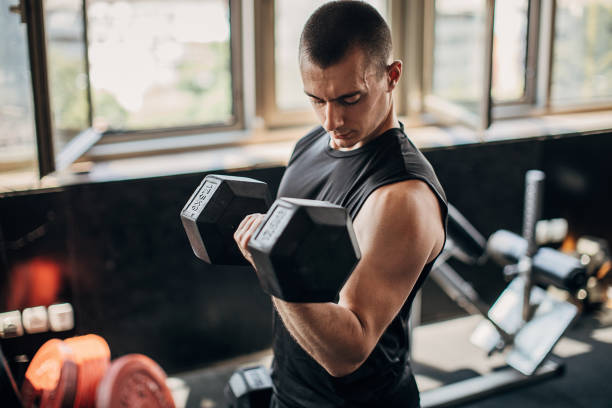 istock Young athlete training with dumbbells in the local gym 1255037046