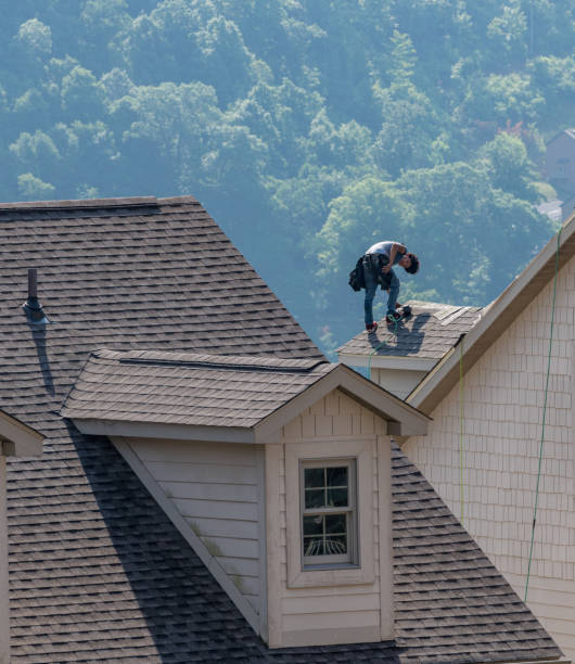 jonge dakbedekkingscontractant die shingles op een dak hoog boven de grond spijkert - timmerman dakkapel stockfoto's en -beelden