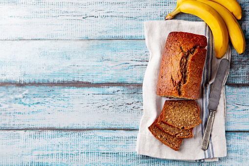 Healthy vegan oat and banana loaf bread, cake. Wooden background. Copy space. Top view.
