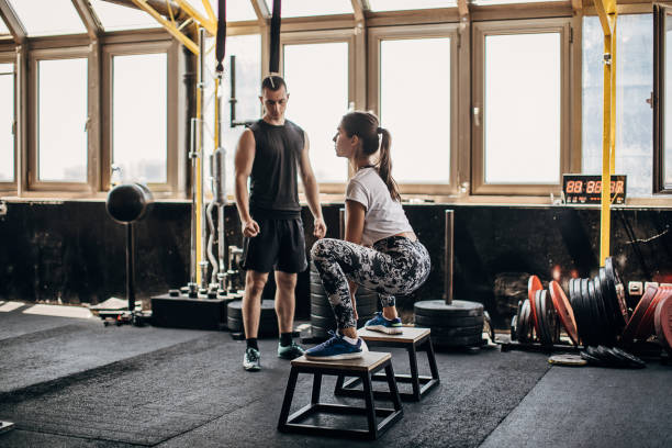 istock One fit woman training with kettlebell with her personal trainer 1255038284