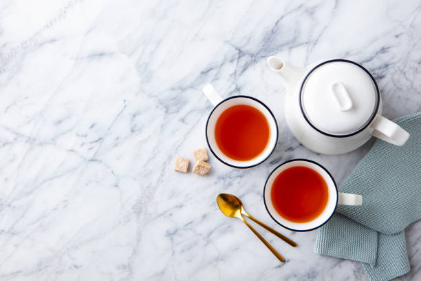 istock Tea in mugs with teapot on marble background. Copy space. Top view. 1255038410