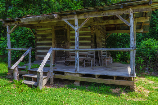 French Camp, Mississippi, USA - June 18, 2020:  An old log cabin on the French Camp Academy grounds along the Natchez Trace Parkway.