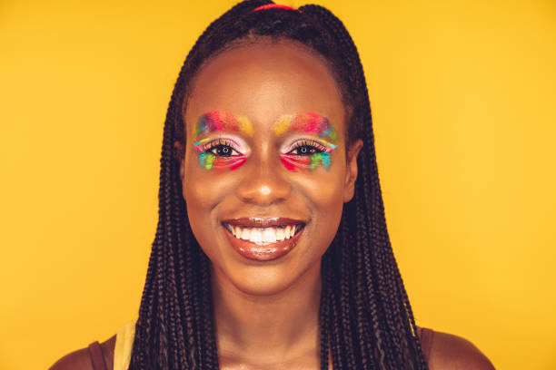 istock Woman posing with a rainbow colored makeup on a yellow background 1255038494