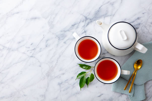 istock Tea in mugs with teapot on marble background. Copy space. Top view. 1255038729