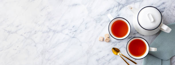 istock Tea in mugs with teapot on marble background. Copy space. Top view. 1255040102