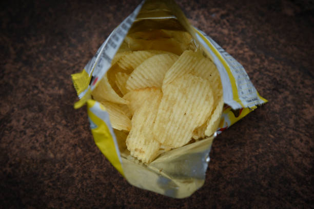 istock Crispy potato chips in bowl on dark table 1255040226