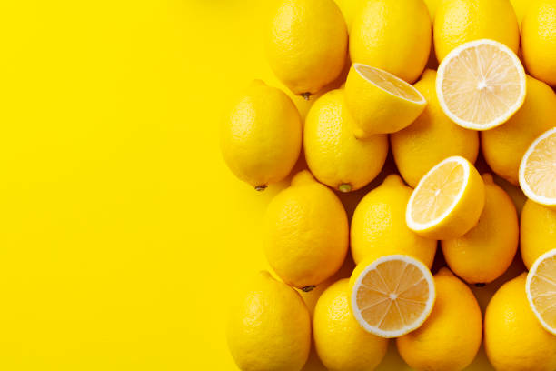 istock Fresh lemons on yellow background. Copy space. Top view. 1255040293