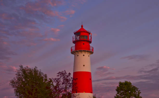 istock A small and beautiful lighthouse in the evening dawn sunset with pink clouds and bright light in Falshöft, Germany 1255041770