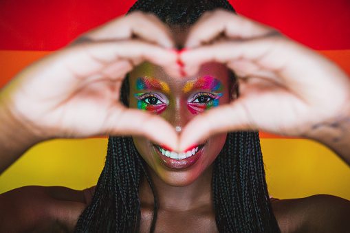 Woman spreading love against a rainbow flag