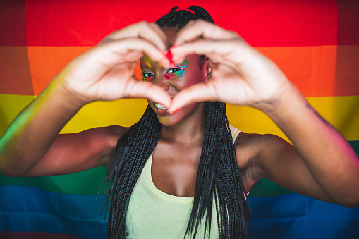 Woman spreading love against a rainbow flag