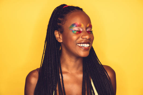 istock Woman posing with a rainbow colored makeup on a yellow background 1255043044