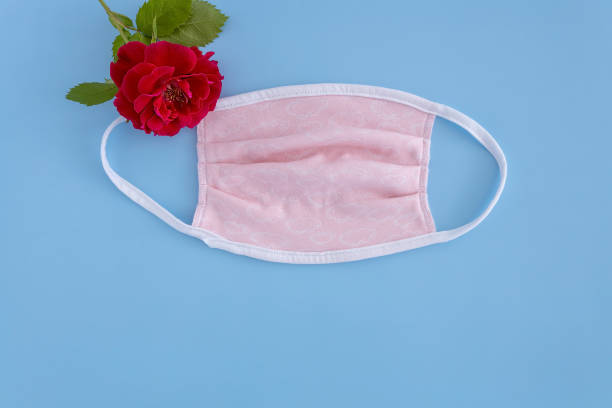 istock medical protective mask and rose on a blue background 1255051127