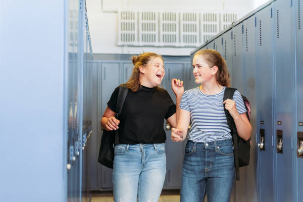 istock Two thirteen year old students are chatting around lockers at school. 1255052560