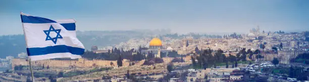 Photo of Israel flag above the old city of Jerusalem.