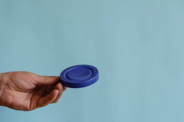 istock Hand holds a blue plastic lid for a can. 1255056407