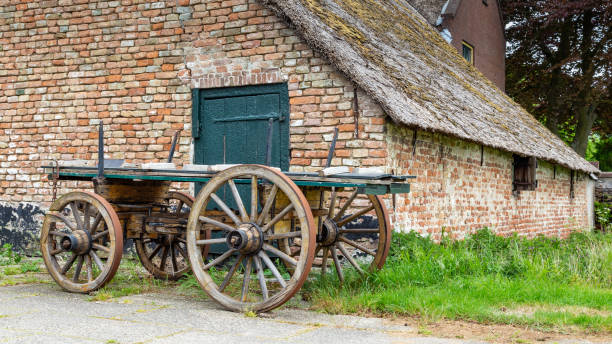 Traditional Dutch farm with thatched roof and an ancientwooden wagon