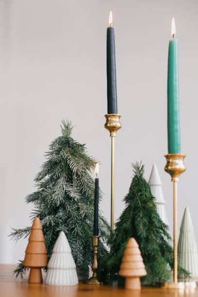 istock Christmas trees and stylish candles on rustic wooden table. Festive modern decor, zero waste. Happy holidays. Miniature wooden and handmade pine trees and candlesticks. 1255058435