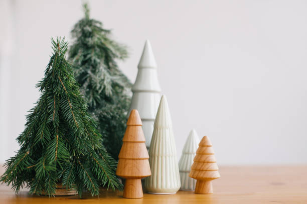 istock Christmas trees on rustic wooden table. Festive modern decor, zero waste. Happy holidays. Miniature wooden, ceramic and handmade pine trees. Copy space 1255058455