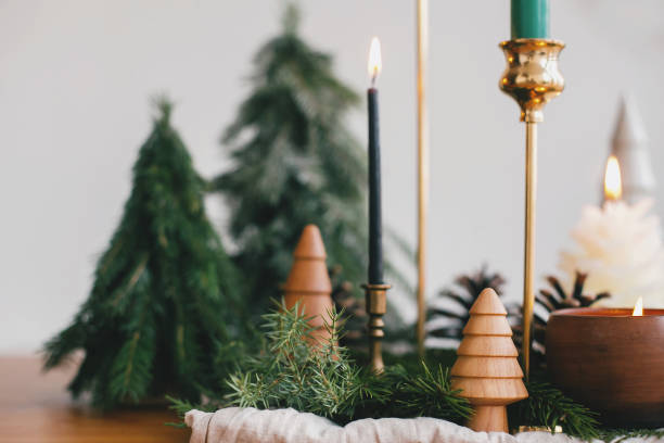 istock Christmas trees, candles and pine cones on rustic fabric on wooden table. Festive modern decor, zero waste. Miniature wooden and handmade pine trees.  Happy holidays 1255058549