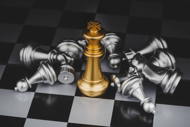 istock Winner. gold king with silver chess pieces on chess board game competition on dark background, chess battle, victory, success, management, team leader, teamwork and business strategy concept 1255059389