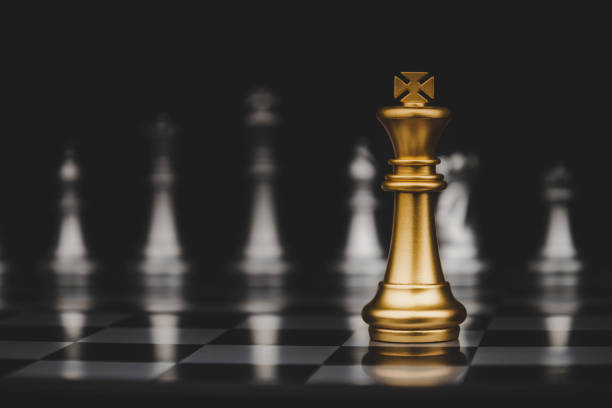 istock Leadership. gold king with silver chess pieces on chess board game competition on dark background, chess battle, victory, success, management, team leader, teamwork and business strategy concept 1255059407