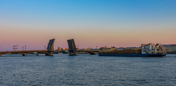 istock General cargo ship with raw wood logs on deck underway on Neva river at summer sunrise. 1255060664